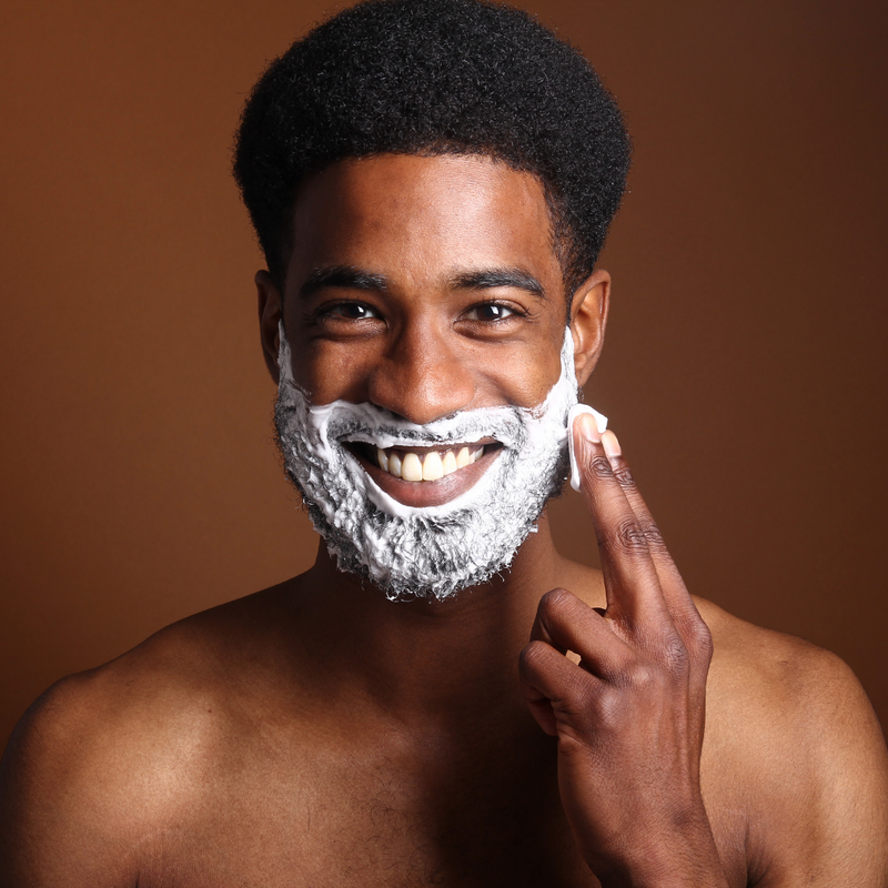 Black man smiling with shaving cream. Men's skincare. Skincare for men. Skincare for black men. Skincare for guys. Skincare routine for men. Acne products for men. Skincare products for men. Natural skincare for men.